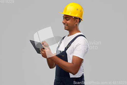 Image of happy indian builder in helmet with tablet pc