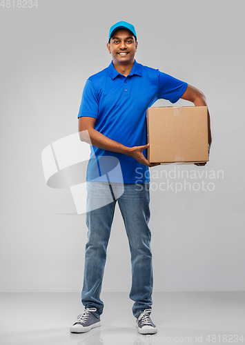 Image of happy indian delivery man with parcel box in blue