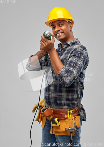 Image of happy indian builder in helmet with electric drill