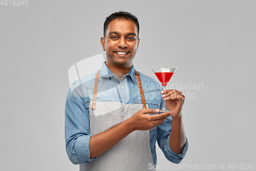 Image of indian barman in apron with glass of cocktail