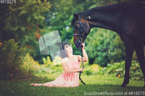 Image of beautiful girl in dress with horse