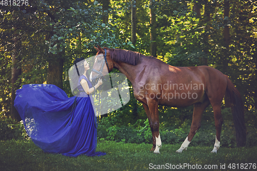 Image of beautiful girl in dress with horse