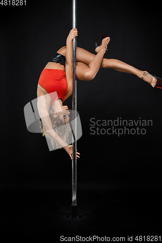 Image of beautiful pole dancer in red top on pylon