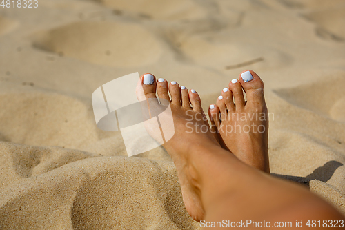 Image of woman\'s legs on sand