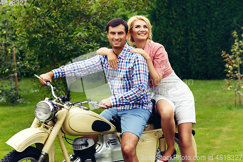 Image of beautiful couple on retro motorbike