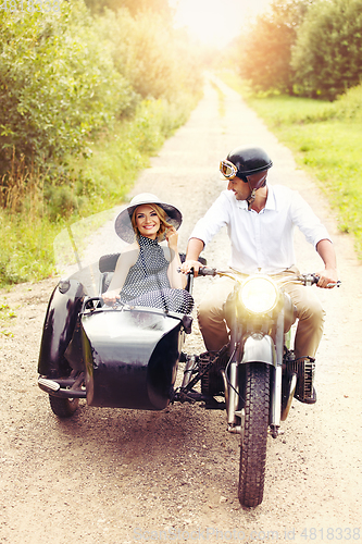 Image of beautiful couple on retro motorbike