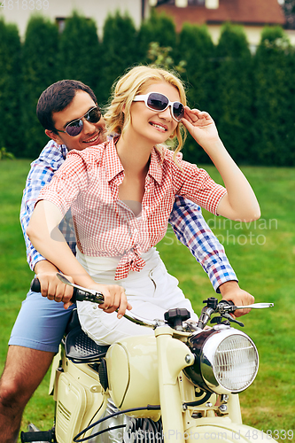 Image of beautiful couple on retro motorbike