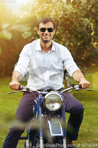 Image of handsome man on retro motorbike