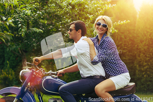 Image of beautiful couple on retro motorbike