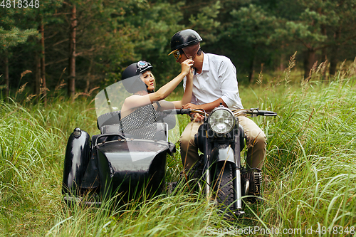 Image of beautiful couple on retro motorbike