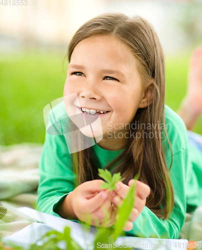 Image of Portrait of a little girl laying on green grass