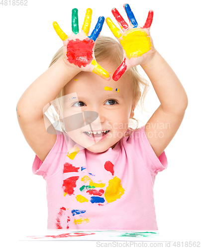 Image of Portrait of a cute little girl playing with paints