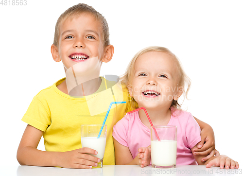 Image of Cute little girl and boy are drinking milk