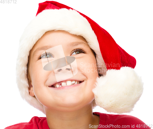 Image of Little girl in santa hat is daydreaming