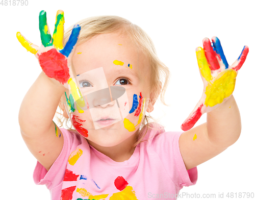 Image of Portrait of a cute little girl playing with paints