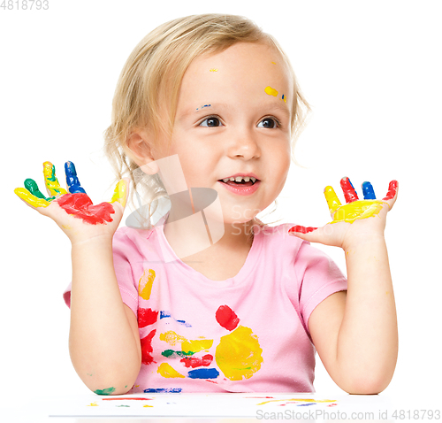 Image of Portrait of a cute little girl playing with paints