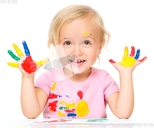 Image of Portrait of a cute little girl playing with paints