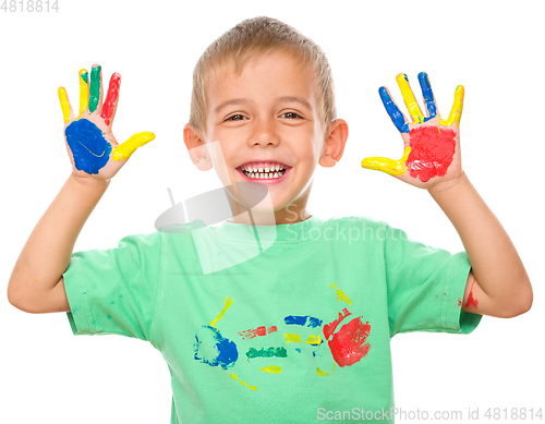 Image of Portrait of a cute boy playing with paints