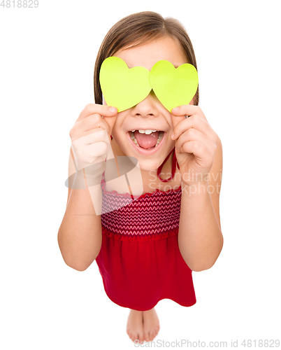 Image of Little girl is holding hearts over her eyes