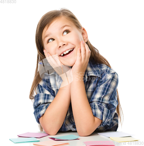 Image of Girl is writing on color stickers using pen
