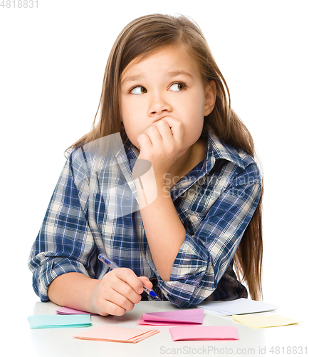 Image of Girl is writing on color stickers using pen