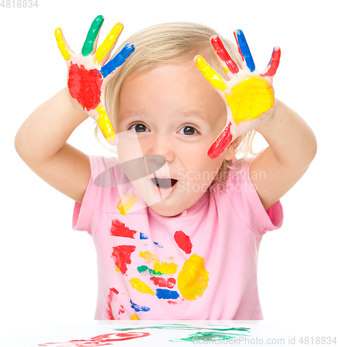 Image of Portrait of a cute little girl playing with paints