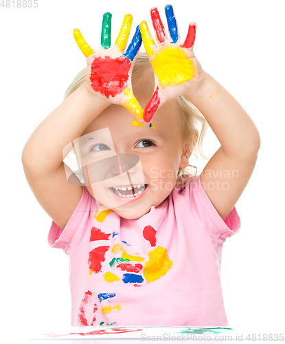 Image of Portrait of a cute little girl playing with paints