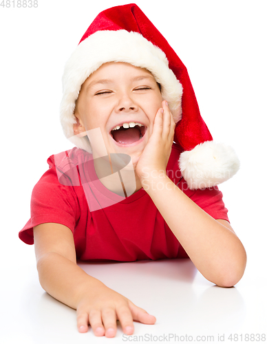 Image of Little girl in santa hat is laughing