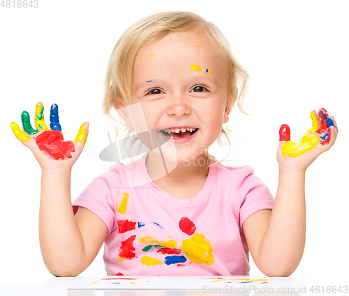 Image of Portrait of a cute little girl playing with paints