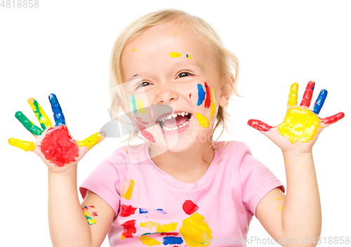 Image of Portrait of a cute little girl playing with paints