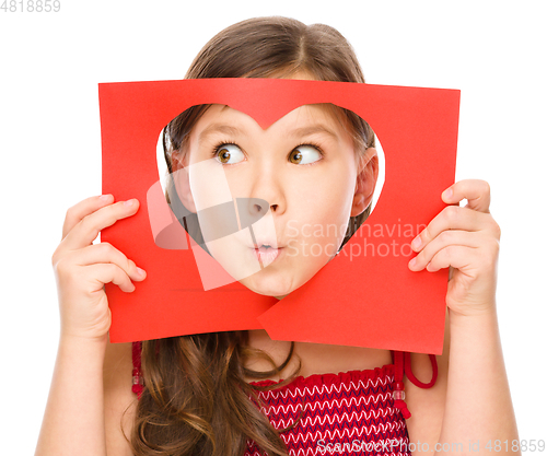 Image of Little girl is looking through heart template