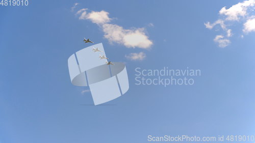 Image of Four fighters Yak-130 fly in blue sky