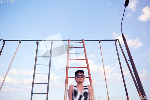 Image of Beautiful woman in black and white striped swimsuit on the old sports ground. Film effect.