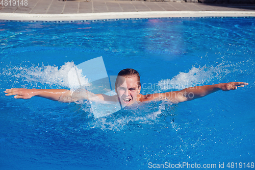 Image of handsome boy swimming in outdoor pool