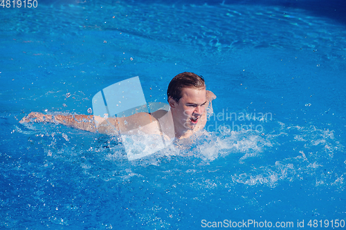Image of handsome boy swimming in outdoor pool
