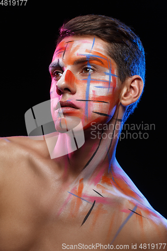 Image of handsome young man with paint strokes on face