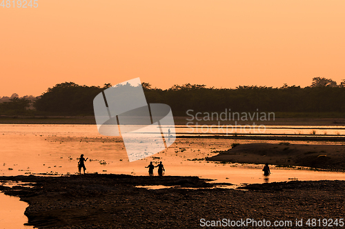 Image of Asian women fishing in the river, silhouette at sunset