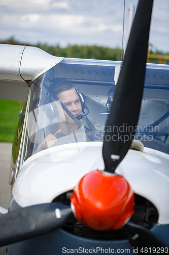 Image of young man in small plane cockpit