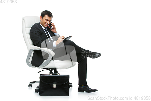 Image of handsome businessman in suit sitting on armchair