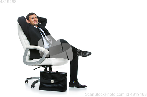 Image of handsome businessman in suit sitting on armchair