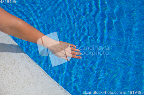 Image of woman\'s hand touching water