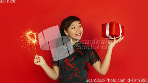 Image of Happy Chinese New Year. Asian young girls\'s portrait isolated on red background