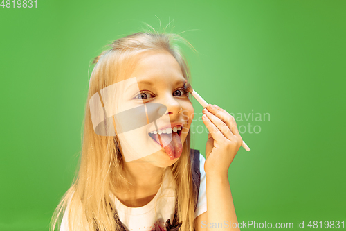 Image of Little girl dreaming about future profession of makeup artist