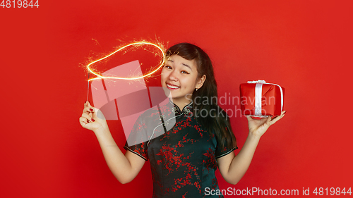 Image of Happy Chinese New Year. Asian young girls\'s portrait isolated on red background