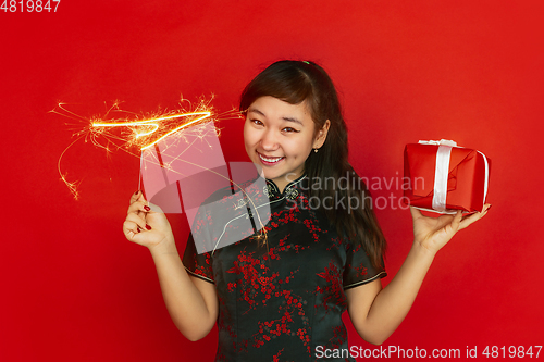 Image of Happy Chinese New Year. Asian young girls\'s portrait isolated on red background