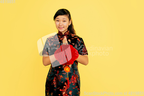 Image of Happy Chinese New Year. Asian young girls\'s portrait isolated on yellow background