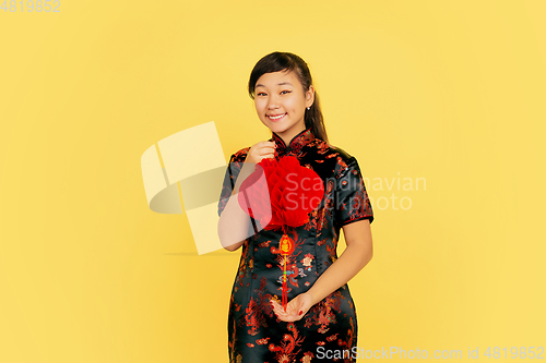 Image of Happy Chinese New Year. Asian young girls\'s portrait isolated on yellow background