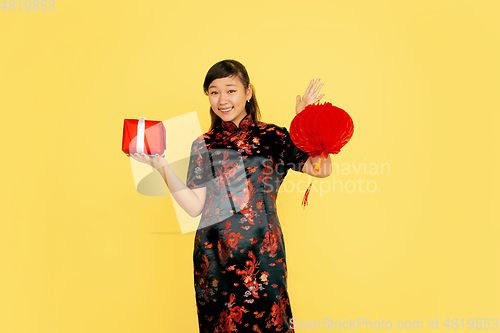 Image of Happy Chinese New Year. Asian young girls\'s portrait isolated on yellow background