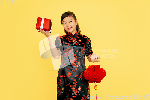 Image of Happy Chinese New Year. Asian young girls\'s portrait isolated on yellow background