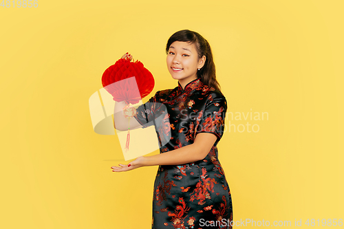 Image of Happy Chinese New Year. Asian young girls\'s portrait isolated on yellow background